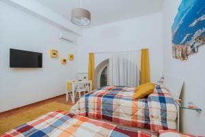 um quarto com uma cama e uma televisão de ecrã plano em Naporà em Nápoles