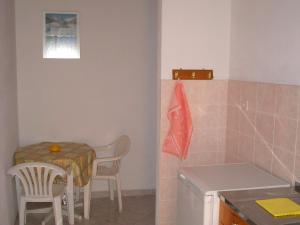 cocina con mesa, mesa y sillas en Apartments Ziogas, en Paralía Skotínis