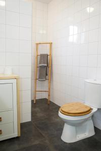 ein Badezimmer mit einem WC und einem Holzsitz in der Unterkunft Gastenverblijf Eenigenburg in Eenigenburg