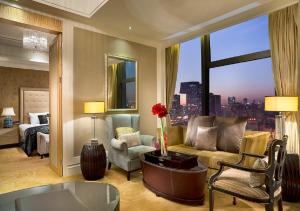 un soggiorno con divano, letto e finestra di Wanda Vista Beijing a Pechino