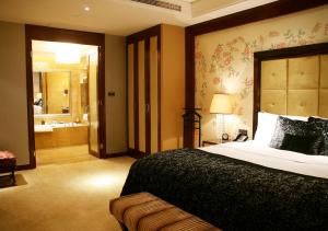 a bedroom with a large bed and a bathroom at Wanda Vista Beijing in Beijing