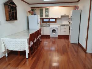 a kitchen with white appliances and a table and chairs at Ok guesthouse in Seoul