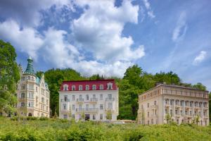 a group of buildings with trees and a sky at Ensana Svoboda in Mariánské Lázně