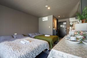 1 dormitorio con 1 cama y 1 mesa con toallas en Akabane TK Building 302, en Tokio