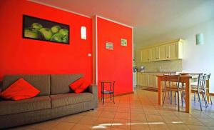 sala de estar con sofá y pared roja en Residence La Collina, en Vercana