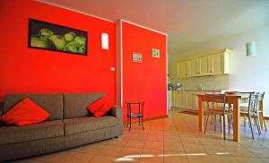 - un salon avec un canapé et un mur rouge dans l'établissement Residence La Collina, à Vercana