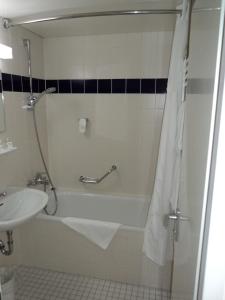 ein Badezimmer mit einer Badewanne und einem Waschbecken in der Unterkunft Holiday Inn Leipzig Günthersdorf, an IHG Hotel in Kötschlitz
