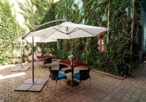 una mesa y sillas con una sombrilla en el patio en Pension Horse Inn en Košice