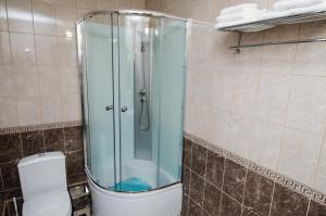 a bathroom with a glass shower with a toilet at Uralochka Hotel in Chelyabinsk