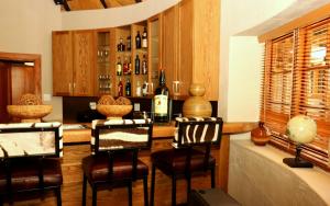 a bar with three chairs and a bottle of wine at Sherewood Lodge in Pretoria