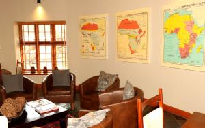 a waiting room with chairs and maps on the wall at Sherewood Lodge in Pretoria