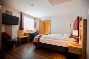 Habitación de hotel con cama grande y escritorio. en Hotel Elefant Family Business en Salzburgo