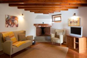 a living room with a tv and a fireplace at Solar Do Magoito in Sintra