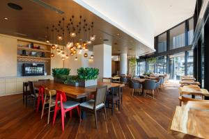 un restaurante con una gran mesa de madera y sillas en Hotel Forza Kanazawa, en Kanazawa