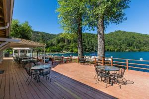 una terraza con mesas y sillas junto a un lago en The Lodge at Blue Lakes en Upper Lake