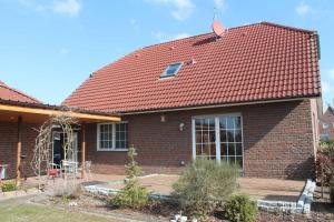 a brick house with a red roof at Ferienwohnung Nordbrock, 65317 in Moormerland