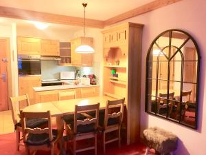 a kitchen with a table and chairs and a mirror at Arc 1950 Apartment - Sources de Marie, Mountain View in Arc 1950