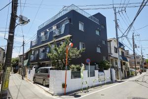 a blue building on the side of a street at Akabane TK Building 303 in Tokyo