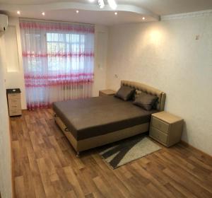 a bedroom with a large bed with a window at Apartment Shevchenka 154 in Nikopolʼ