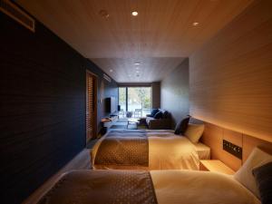 a hotel room with two beds and a couch at Kumano-bettei Nakanoshima in Katsuura