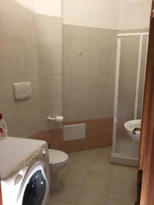 a bathroom with a toilet and a shower and a washing machine at Da noi. Nella città dell'acqua e della pietra. in Gravina in Puglia +13 photos