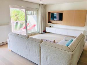 a living room with a couch and a tv at EastDune in Oostduinkerke