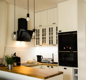 uma cozinha com armários brancos e electrodomésticos pretos em Apartament MANSARDA em Września