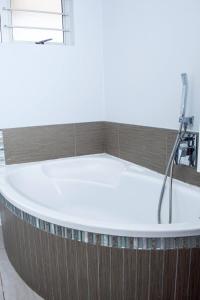 Lofts on Lorna في باليتو: حوض استحمام مع صنبور في الحمام