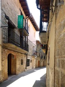 an alley with a green sign on the side of a building at Casa Torralba in El Frago