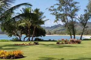 un parque con palmeras y un cuerpo de agua en Lae Nani 326, en Kapaa