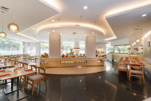 a restaurant with wooden tables and chairs and a counter at HARRIS Hotel Tebet Jakarta in Jakarta