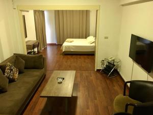 a living room with a couch and a table and a bed at Divan Hotel Apartments in Beirut