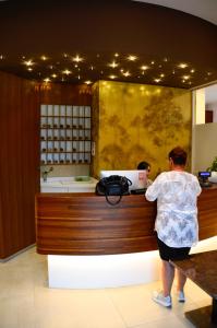 a woman standing at a cash register in a store at Hotel Shangri-La in Ala