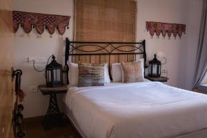 sypialnia z dużym łóżkiem z białą pościelą i poduszkami w obiekcie The Secret House - Adults Only w mieście Jaisalmer