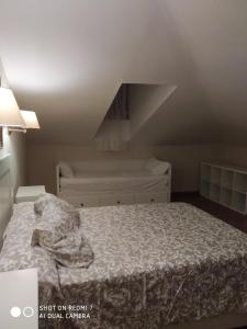 1 dormitorio con 1 cama con edredón blanco en Apartamento Las Musas, en Santiponce