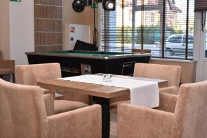 una sala da pranzo con tavolo e sedie da biliardo di ALKA Sun Resort a Ustronie Morskie