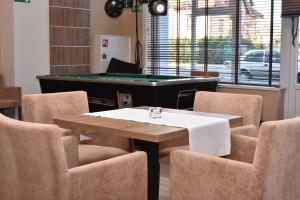 a dining room with a pool table and chairs at ALKA Sun Resort in Ustronie Morskie