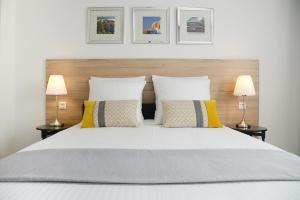 - une chambre avec un grand lit blanc et deux lampes dans l'établissement Business Appart, à Tourcoing