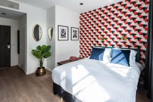 sypialnia z dużym łóżkiem z czerwonym zagłówkiem w obiekcie YAYS Paris Issy w mieście Issy-les-Moulineaux