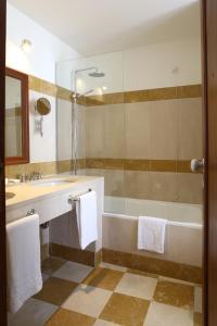 a bathroom with a shower, sink, and mirror at Hotel Quinta das Lagrimas - Small Luxury Hotels in Coimbra