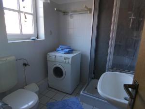 ein Badezimmer mit einer Waschmaschine und einem Waschbecken in der Unterkunft Ferienwohnung Achter`d Diek, 45183 in Jemgum