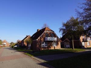 ein Haus an der Seite einer Straße in der Unterkunft Ferienwohnung Achter`d Diek, 45183 in Jemgum