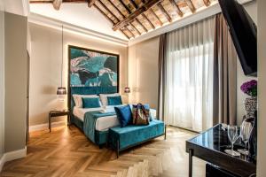 a bedroom with a bed and a blue couch at Hotel 55 Fifty-Five - Maison d'Art Collection in Rome