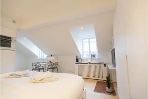 a white room with a bed and a table at Smartflats - Luxembourg in Luxembourg