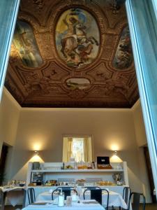 a restaurant with a ceiling with a painting on it at Hotel Palazzo Vannoni in Levanto
