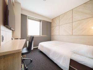 a hotel room with a bed and a desk at Super Hotel Umeda Higobashi in Osaka