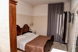 a bedroom with a bed with a wooden head board at Business Hotel in Casoria