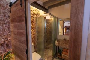 baño con ducha y puerta de cristal en Domus Lapidis - El Taller en Bogarra