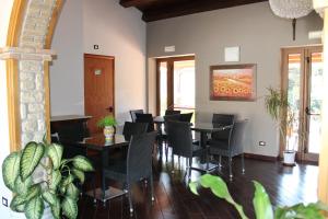 een eetkamer met tafels en stoelen en een schilderij bij Casale Margherita in Cammarata