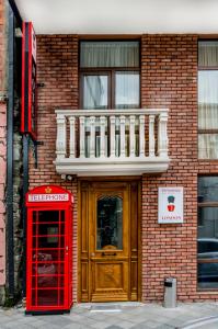 a red phone booth and a building with a red door at Hotel London in Batumi